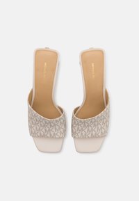 Beige Sandalen mit strukturiertem MK-Monogramm-Obermaterial und glatten, matten beigen Sohlen. Mit offener Zehen- und rückenfreier Gestaltung.