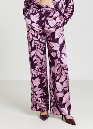 Pantaloni floreali viola con motivi a foglia rosa, realizzati in tessuto di satin. Presentano un design a gamba larga e una vestibilità sartoriale, abbinati a tacchi a stiletto.