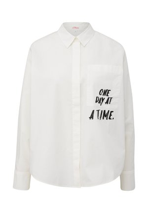 Chemise blanche à boutonnières, en coton, avec une coupe décontractée. Elle comporte une poche sur la poitrine gauche et un texte imprimé en noir : "UN JOUR À LA FOIS."