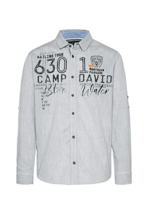 Chemise boutonnée gris clair avec des graphismes textuels noirs, incluant des thèmes nautiques. Équipée d'un col et de manches longues. Tissu texturé.