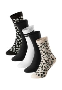 Vijf paar sokken in zwart, wit en beige met patronen, waaronder luipaardprint en polkadots, gemaakt van een zacht materiaal.