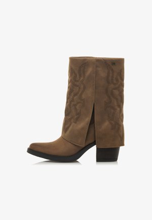 Botte de cowboy en daim marron avec un design de couture incurvé, un bout pointu et un talon épais. Présente une fente latérale et une surface texturée.