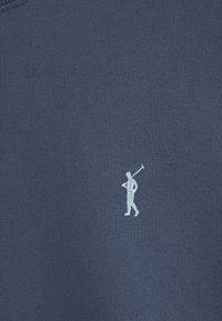 Marinblå bomullströja med en liten vit broderad figur som håller en golfklubba på vänster bröstområde, med ribbad halsringning.