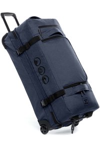 Dunkelblaue Rollreisetasche mit Stoffaußenfläche, mehreren Reißverschlüssen, verstellbaren Trägern und stabilen Rädern für einen einfachen Transport.