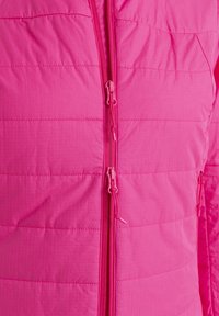 Světlá růžová zateplená bunda s prošívaným designem, dvojitým zipem a texturovanou tkaninou s jemnými mřížkovými vzory.