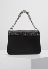 Borsa nera con forma strutturata, dotata di una patta metallica texturizzata con un motivo e di una tracolla intrecciata. Corpo in pelle liscia.