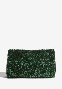 Bolso de mano rectangular verde oscuro cubierto de lentejuelas brillantes con cierre de solapa, proyectando una sombra sobre una superficie blanca.