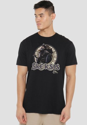 Black cotton t-shirt featuring a graphic print of a character from "The Dark Crystal," with circular and text accents in light colors.