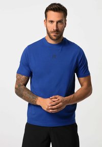 Blauwe T-shirt met korte mouwen, gemaakt van zacht materiaal, met een ronde hals en een klein zwart logo op de borst. Glad oppervlak, ontspannen pasvorm.