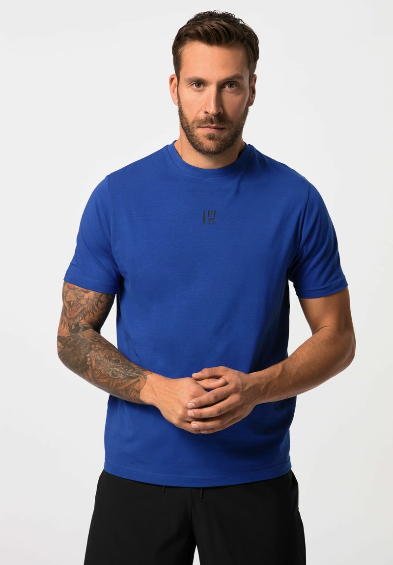 Blauwe T-shirt met korte mouwen, gemaakt van zacht materiaal, met een ronde hals en een klein zwart logo op de borst. Glad oppervlak, ontspannen pasvorm.