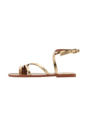 Sandalo piatto marrone con cinturini intrecciati in oro metallizzato, cinturini sagomati sulla punta e chiusura con fibbia alla caviglia.