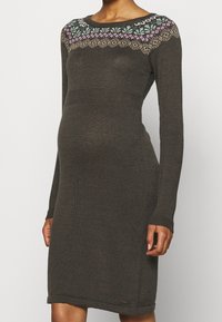 Abito in maglia a maniche lunghe, di colore marrone scuro, con vita aderente e una vivace yoke a fantasia con accenti verdi, viola e beige. Finitura texturizzata.