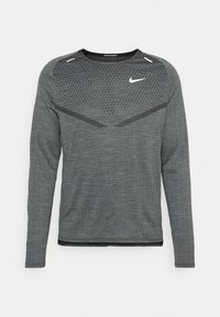 Langärmeliges graues Nike-Laufshirt mit Strukturmuster, schwarzen Akzenten und einem weißen Nike-Swoosh auf der oberen Brust.