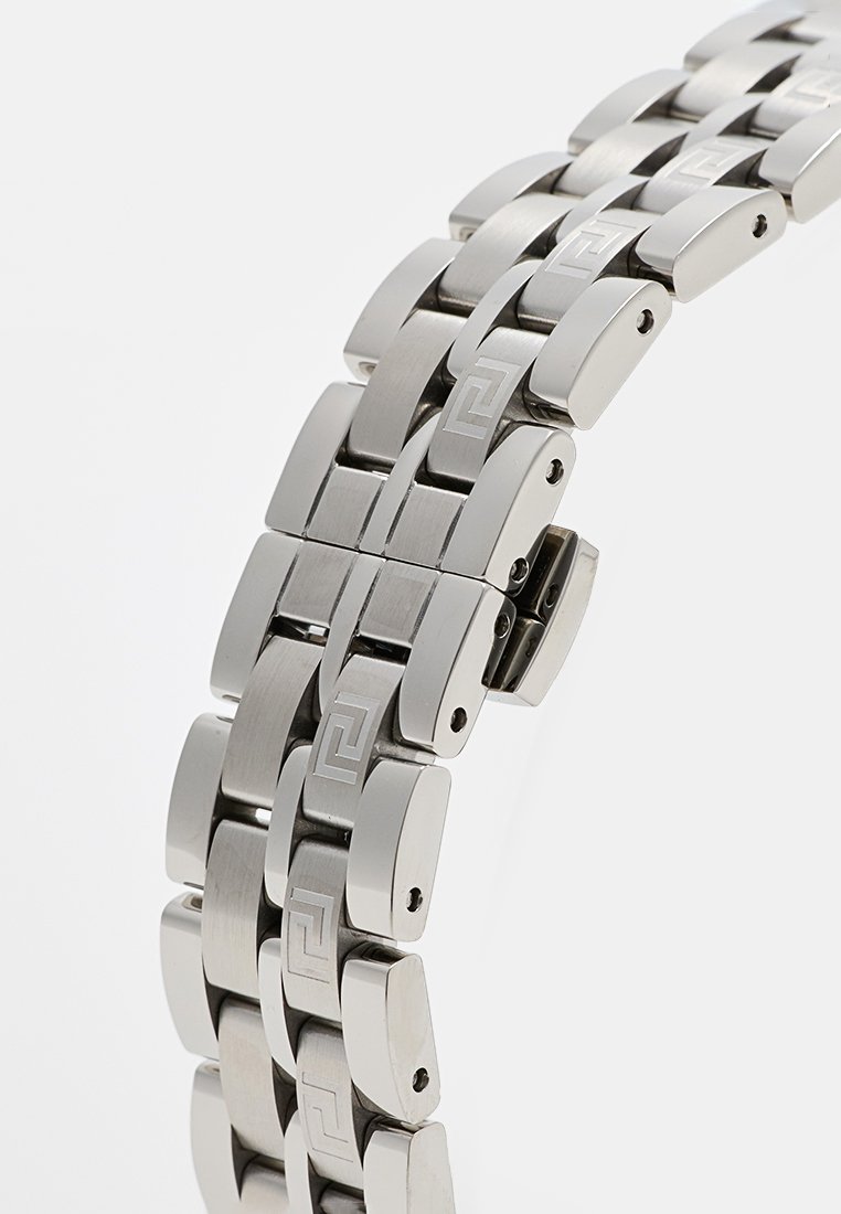 Bracelet de montre en métal avec une finition en acier inoxydable poli et brossé, des maillons rectangulaires entrelacés et un motif gravé.