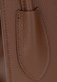 Borsa a tracolla in pelle marrone con una finitura testurizzata, caratterizzata da un design elegante e cuciture di rinforzo lungo i bordi.