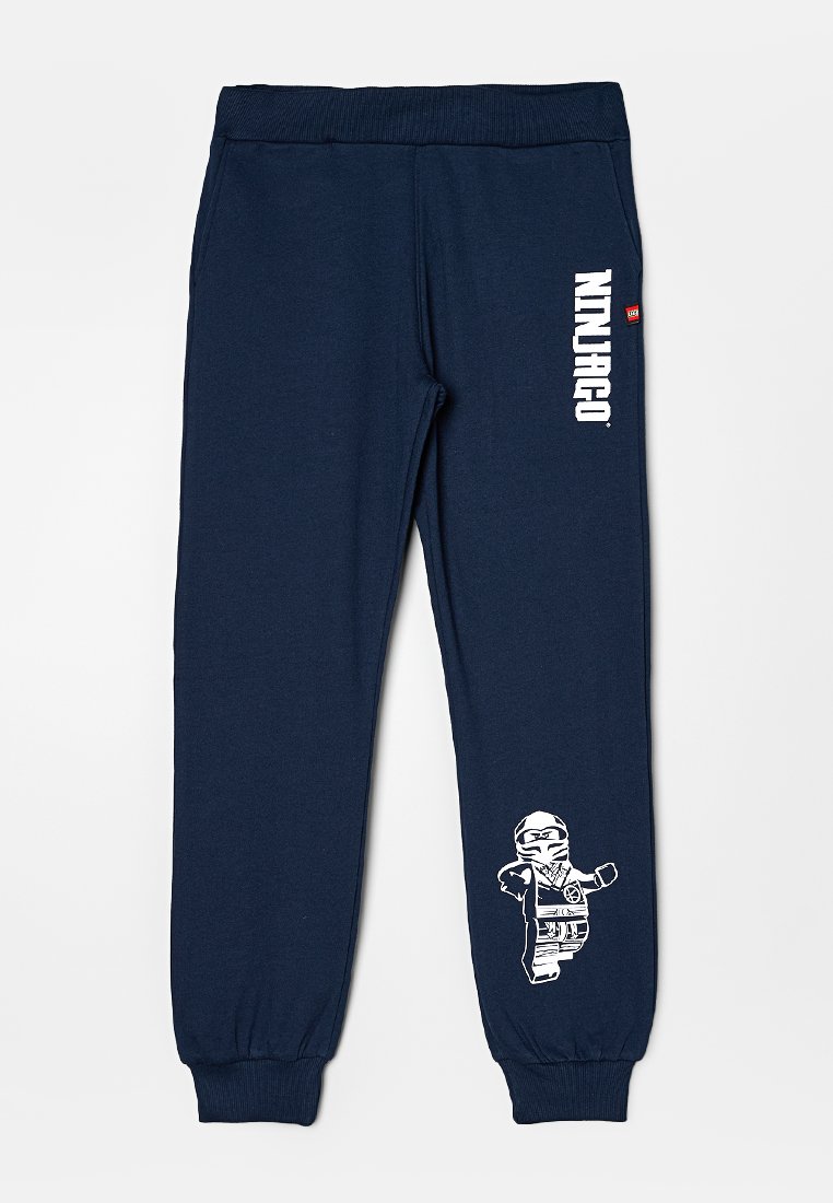 Pantalons de survêtement navy avec taille élastique et poignets. Présente un texte "NINJAGO" blanc et un graphique de ninja sur la jambe inférieure. Tissu doux.