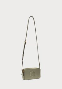 Olivově zelená kožená crossbody taška s embosovaným logem, zipovým uzávěrem, nastavitelným popruhem a obdélníkovým tvarem. Hladký povrch a zlaté kovové doplňky.