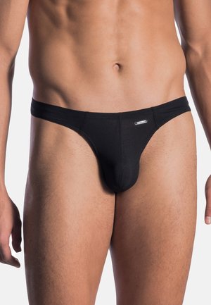 Schwarze String-Unterwäsche aus Baumwolle. Sie zeichnet sich durch eine glatte Textur, ein minimalistisches Design und eine körperbetonte Form mit einem elastischen Bund aus.