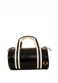 Sort duffel bag med cremefarvede håndtag og remme. Har en tekstureret overflade og et guld logo på den ene side. Lynlås lukning.