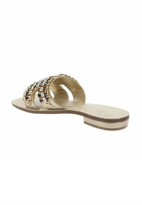 Sandalo piatto dorato con suola piatta, dotato di due anelli e cinturini decorati con strass trasparenti e neri. Plantare testurizzato per il comfort.