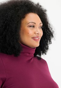 Burgundy turtleneck top made of soft jersey fabric, featuring a fitted design and smooth texture, with a high neckline and short sleeves.