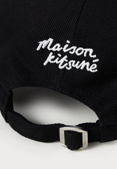 Crni platneni šešir na poleđini s bijelim izvezenim logotipom "maison kitsuné" i podesivim tkanim remenom koji je osiguran srebrnom metalnom kopčom.