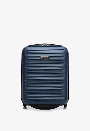 Harde koffer in donkerblauw met verticale ribbels, voorzien van een handvat aan de bovenkant, ritssluiting en staat op vier wielen voor mobiliteit.
