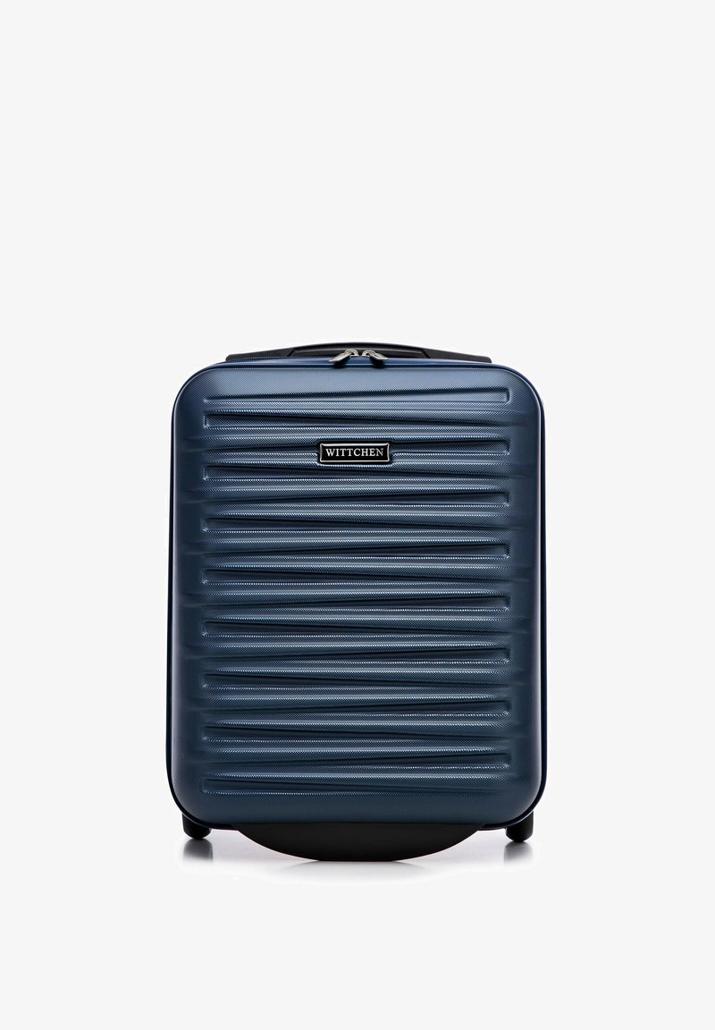 Harde koffer in donkerblauw met verticale ribbels, voorzien van een handvat aan de bovenkant, ritssluiting en staat op vier wielen voor mobiliteit.