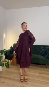 Bordirana haljina od čipke s dugim, prozirnim rukavima, opuštenog kroja i cvjetnim uzorkom. Uparena s smeđim sandalama na platformu i smeđom torbom.