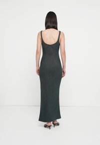 Gray denim maxi dress with a fitted silhouette, scoop back, and thick straps. Hem accentuated by visible stitching and subtle texture.