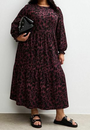 Černé a vínové maxi šaty s leopardím potiskem, dlouhými rukávy, vrstveným designem a kulatým výstřihem. Doplňky zahrnují černou kabelku a sandály.