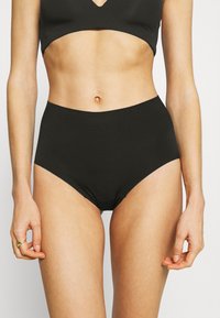 Black high-waisted underwear made of smooth fabric, featuring a seamless design and full coverage, with a soft waistband for comfort.