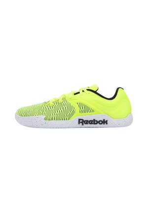 Neongelber Reebok Sportschuh mit schwarzem Logo auf weißer Sohle und schwarzem Innenfutter, von der Seite auf weißem Hintergrund abgebildet.