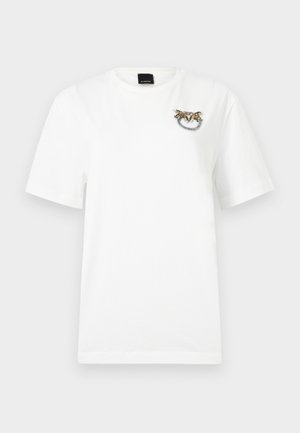 Άσπρο κοντομάνικο T-shirt με μικρό διακοσμητικό κόσμημα και χάντρες στο άνω αριστερό μέρος του στήθους.