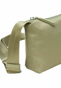 Beige Umhängetasche aus glattem Nylon. Verfügt über einen Reißverschluss oben und einen verstellbaren Trageriemen mit texturiertem Finish und metallischen Hardwaredetails.