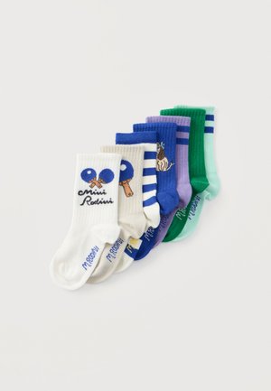 Siedem par kolorowych dziecięcych skarpet ułożonych w rzędzie, z motywami grzybów, pasków i zwierząt w kolorach białym, niebieskim, fioletowym, zielonym i miętowym.