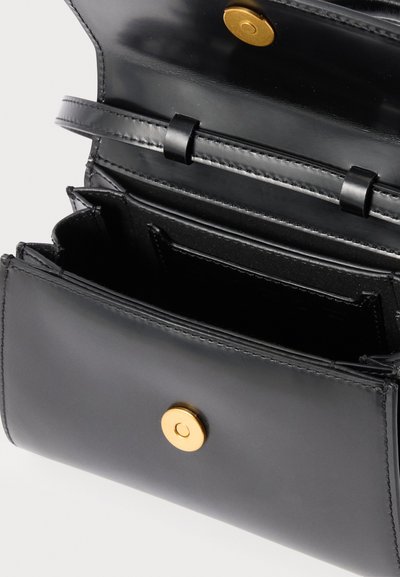 Čierna kožená peňaženka otvorená, ukazujúca viacero priehradiek na karty a zlaté gombíkové zapínanie na hladkom vonkajšom povrchu.