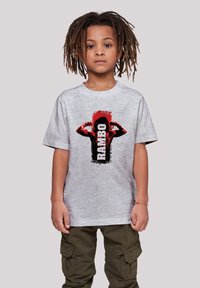 Gray cotton T-shirt featuring a bold black and red graphic of a flexing figure and the word "RAMBO" in black text, relaxed fit, and short sleeves.