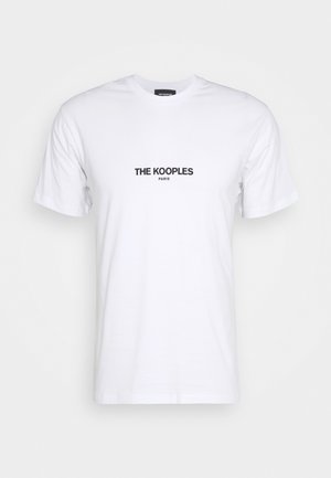 Valkoinen lyhythihainen t-paita, jossa musta teksti "THE KOOPLES PARIS" keskitettynä rinnan kohdalle yksinkertaisella valkoisella taustalla.