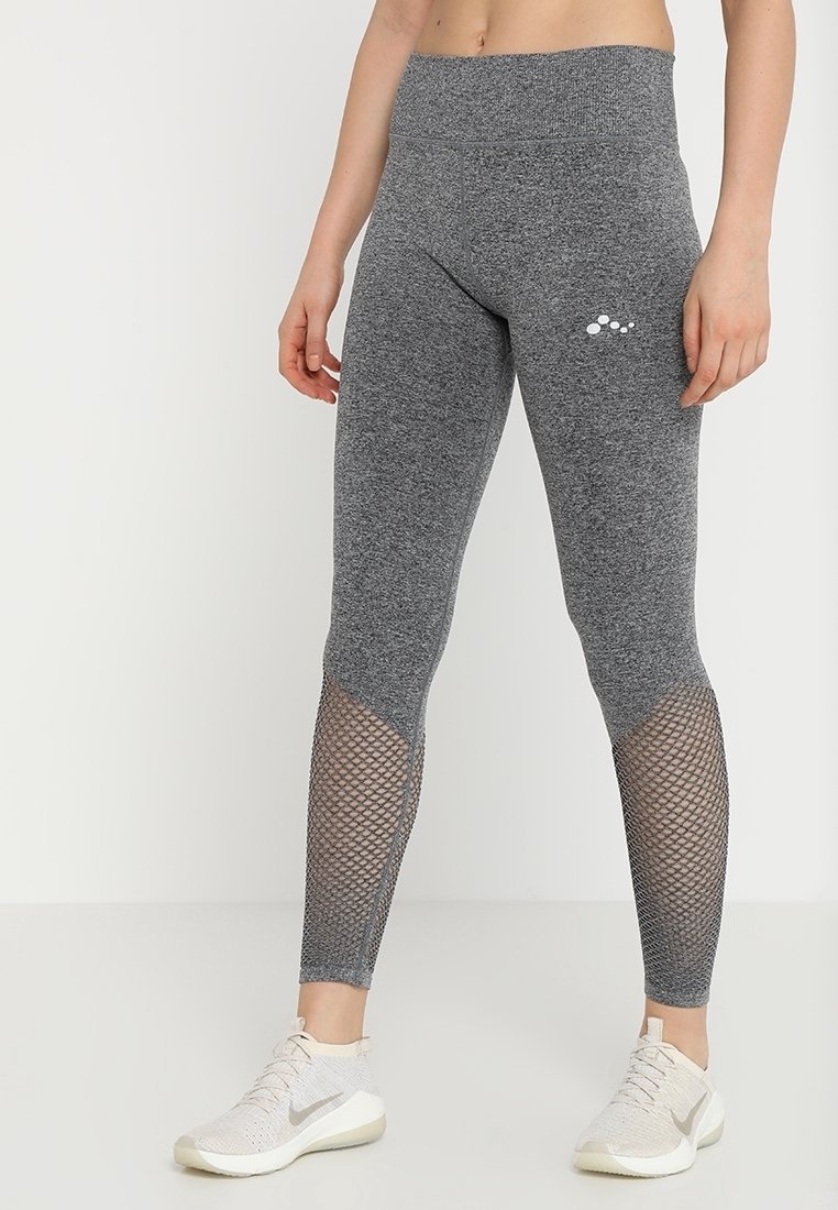 Szare legginsy wykonane z elastycznego materiału, z siateczkowymi panelami na dolnych partiach nóg oraz gładką talią. Zawierają małe logo na biodrze.