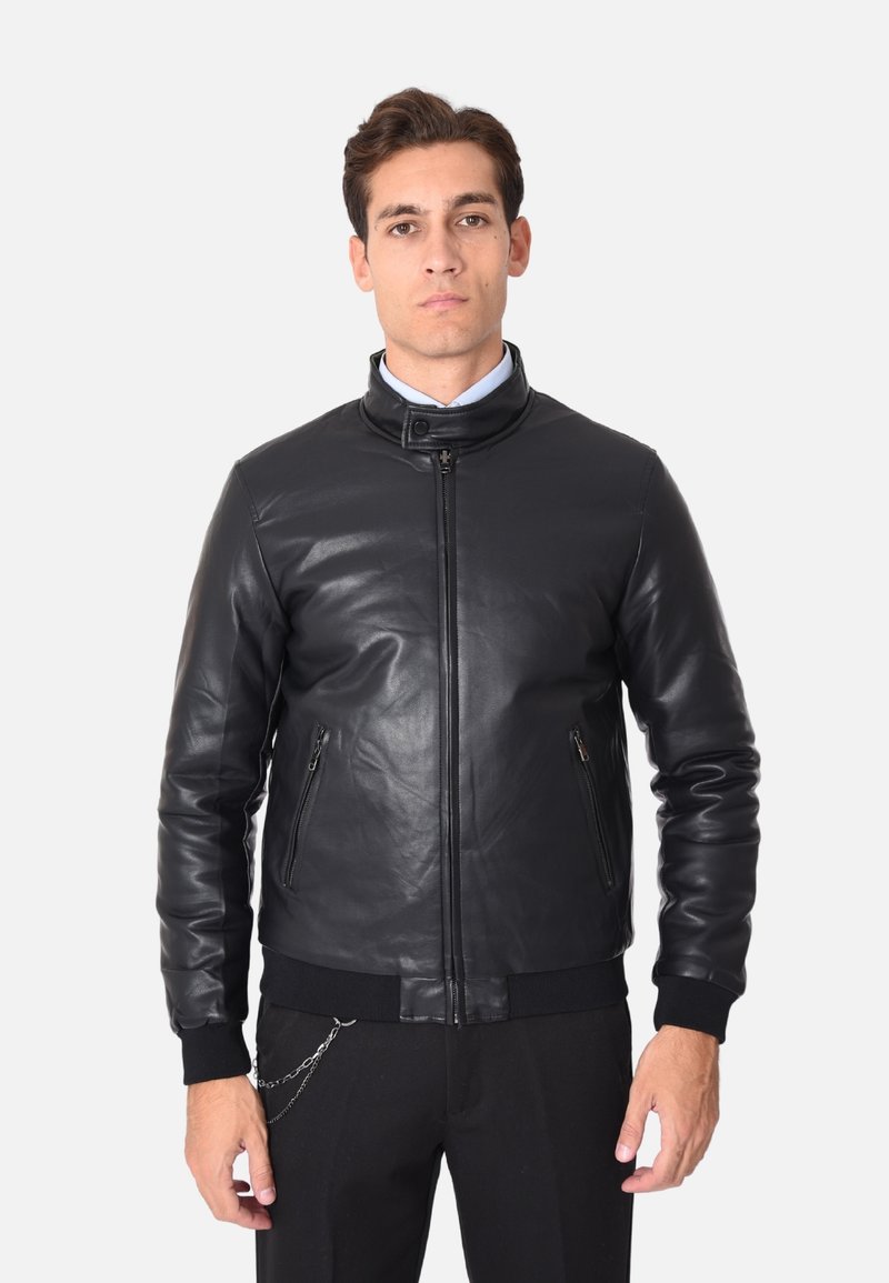Giubbotto bomber in pelle nera con colletto stand, chiusura frontale con zip e due tasche laterali. Polsini e orlo a coste. Texture liscia, hardware minimale.