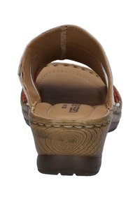 Tan open-back sandal with a low wedge heel, featuring a smooth leather upper and decorative stitching. Textured sole for grip.