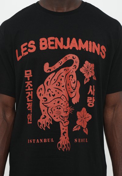 Black cotton t-shirt featuring red graphic design of a leopard and flowers, with text "LES BENJAMINS," "ISTANBUL," and "SEOUL."