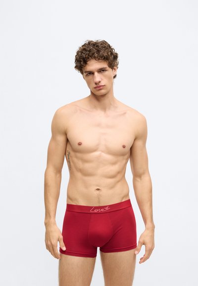 Červené boxerky z bavlny s ružovým nápisom „Love“ na pásiku, s priliehavým strihom a hladkým povrchom.
