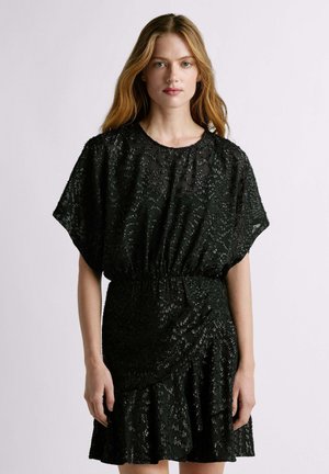 Vestido negro con una superposición transparente texturizada con patrones sutiles. Mangas cortas y una cintura elástica que crean un ajuste relajado.