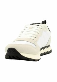 Sneaker con una toma superiore in suede bianco e grigio chiaro e mesh, dettagli neri, suola in gomma testurizzata e motivo zigzag a contrasto.