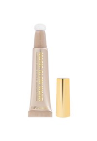 Illuminante liquido in un tubo beige con una morbida punta applicatrice bianca. Lettere dorate sul tubo, accompagnate da un tappo dorato lucido.