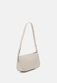Sac à main beige clair avec un motif crocodile texturé, doté d'une fermeture éclair et de quincaillerie en argent, ainsi que d'une bandoulière amovible.
