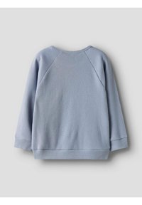 Pull en maille gaufrée bleu clair à manches longues, vu de dos sur un fond gris clair uni.