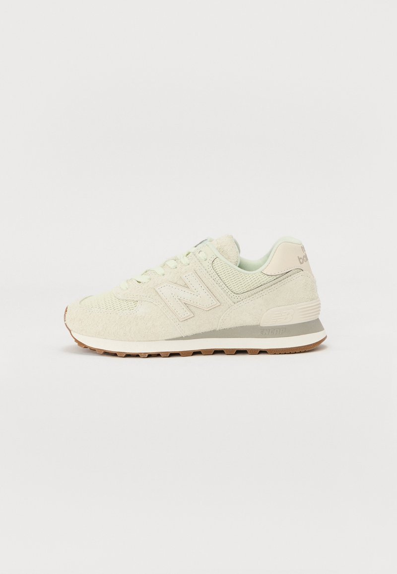 Světlé zelené tenisky New Balance s texturovaným svrškem, měkkými semišovými a síťovinovými materiály a gumovou podrážkou s hnědými akcenty.